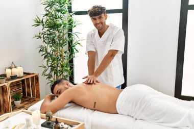 İki İspanyol erkek fizyoterapist ve hasta güzellik merkezinde masaj yapıyorlar.