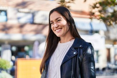 Sokakta kendinden emin gülümseyen genç bir kadın