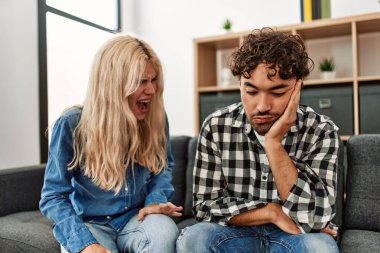 Genç bir çift kanepede oturup tartışıyor..