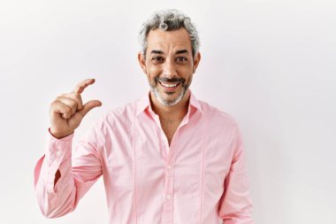 Orta yaşlı İspanyol bir adam izole edilmiş arka planda duruyor gülümsüyor ve kendinden emin bir şekilde el hareketi yapıyor parmaklarıyla işaret yapıyor ve kameraya bakıyor. ölçüm kavramı. 