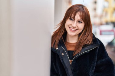 Sokakta kendinden emin gülümseyen genç bir kadın