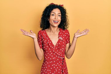 Yazlık elbise giyen genç Latin kız çılgın ve başarıyı kollarını kaldırıp heyecanla haykırarak kutluyor. Kazanan konsept 