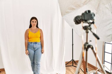 Fotoğrafçılık stüdyosunda model olarak poz veren genç, güzel İspanyol kadın yüzünde ciddi bir ifadeyle rahatladı. Basit ve doğal bir şekilde kameraya bakıyorsun.. 