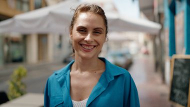 Sokakta kendinden emin gülümseyen genç bir kadın