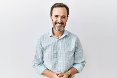 Orta yaşlı, sakallı, soyutlanmış arka planda el ele tutuşmuş, gülümseyen, gevşemiş ve neşeli bir adam. Başarı ve iyimserlik 