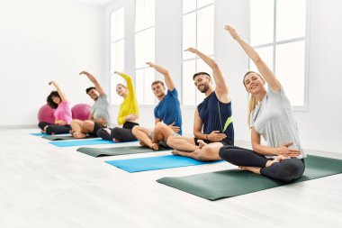 Spor merkezinde mutlu bir yoga eğitimi veren bir grup genç..
