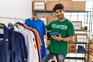 Yardım merkezinde dokunmatik ped kullanan gönüllü üniformalı bir İspanyol genç.