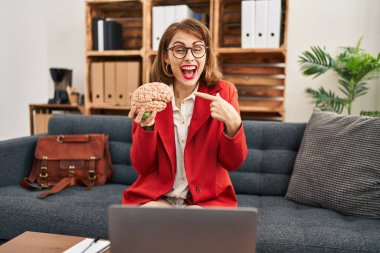 Muayenehanedeki genç esmer kadın elinde beyinle mutlu bir şekilde elini ve parmağını gösterdi. 