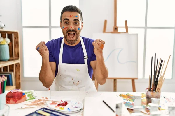 Young Hispanic Man Beard Art Studio Painted Face Celebrating Surprised — Fotografia de Stock