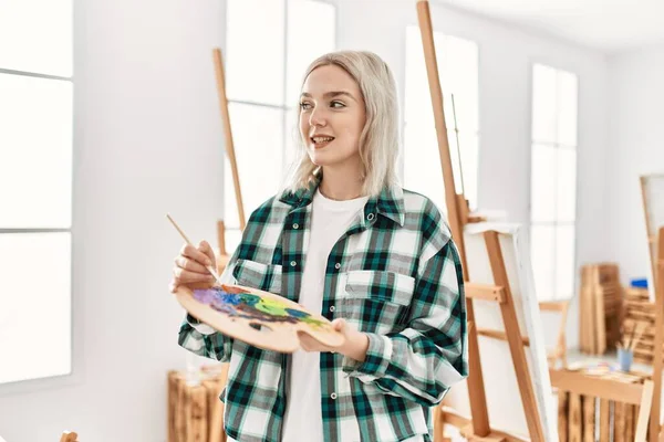 在艺术工作室拿着画笔和调色板 年轻的女艺术家开心地微笑着 — 图库照片
