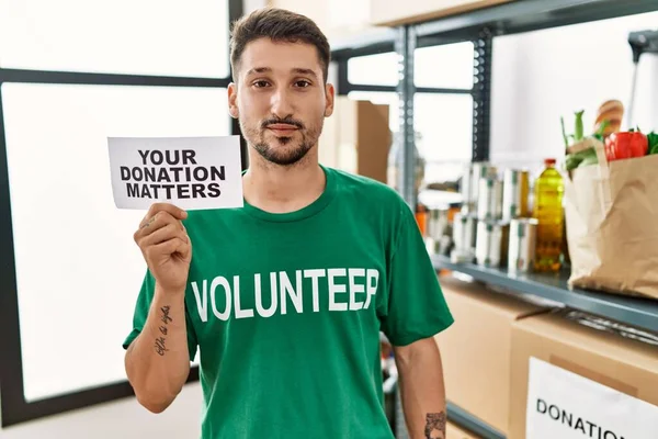 Young Volunteer Man Holding Your Donation Matters Banner Thinking Attitude — Stock Photo, Image