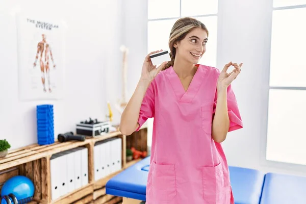 Ağrı Kesici Kliniğinde Çalışan Genç Fizyoterapist Kadın Elinde Kredi Kartıyla — Stok fotoğraf