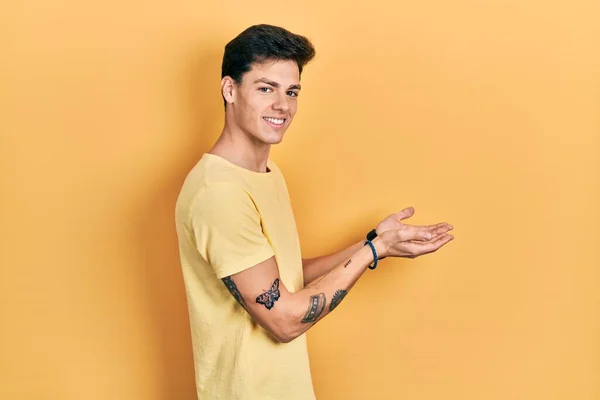Young Hispanic Man Wearing Casual Yellow Shirt Pointing Aside Hands — Stok fotoğraf