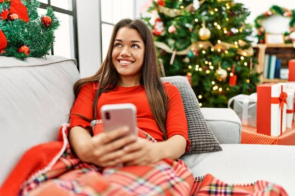 Mladá Latinka Žena Pomocí Smartphone Sedí Vánočního Stromečku Doma — Stock fotografie
