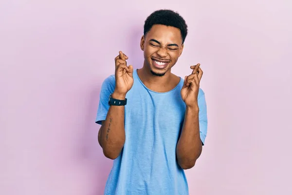 Mladý Afroameričan Neformální Modré Tričku Nadějí Zavřenýma Očima Zkřížil Prsty — Stock fotografie
