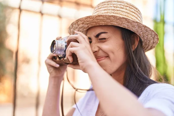 Young hispanic woman tourist smiling confident using camera at street