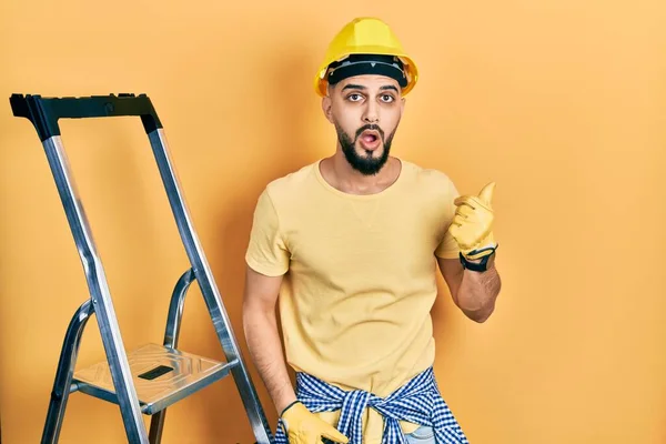 Handsome Man Beard Construction Stairs Wearing Hardhat Surprised Pointing Hand — 스톡 사진