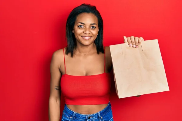 Young African American Girl Holding Take Away Paper Bag Looking —  Fotos de Stock