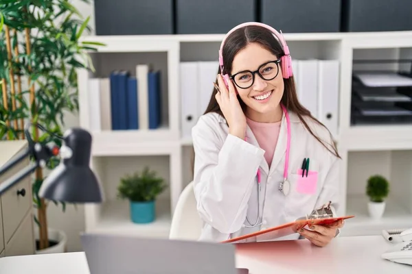 Young Woman Wearing Doctor Uniform Listening Music Working Clinic — стоковое фото