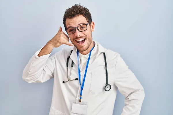Jonge Spaanse Man Doktersuniform Stethoscoop Glimlachend Telefoongebaar Makend Met Hand — Stockfoto