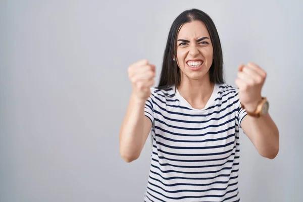 Young Brunette Woman Wearing Striped Shirt Angry Mad Raising Fists — Stock Photo, Image