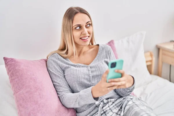 Junge Frau Sitzt Mit Smartphone Schlafzimmer Auf Bett — Stockfoto