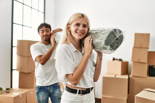 Jovem Lindo Casal Sorrindo Feliz Segurando Tapete Nova Casa — Fotografia de Stock