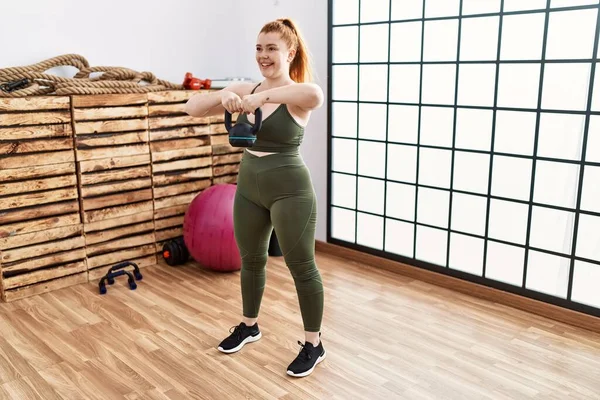 Mujer Pelirroja Joven Sonriendo Entrenamiento Seguro Con Kettlebell Centro Deportivo —  Fotos de Stock