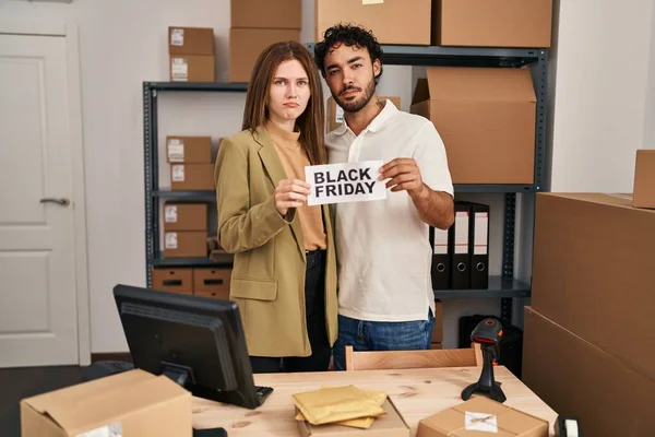 Young two people holding black friday banner at small business store depressed and worry for distress, crying angry and afraid. sad expression.