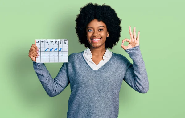 Young African American Woman Holding Travel Calendar Doing Sign Fingers — Stok fotoğraf