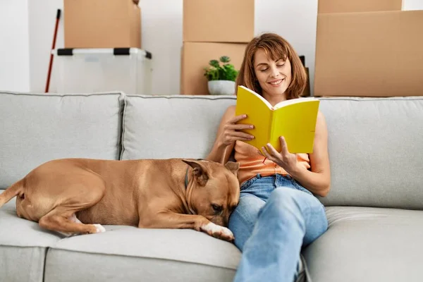 Jovem Caucasiana Leitura Livro Sentado Sofá Com Cão Casa — Fotografia de Stock