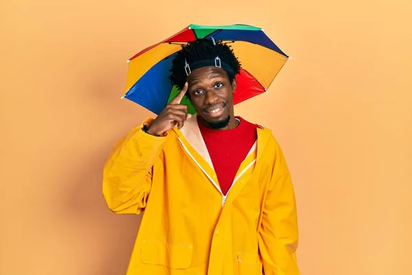 Young African American Man Wearing Yellow Raincoat Smiling Pointing Head — Stock Photo, Image