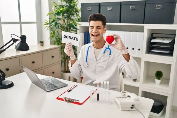 Young Hispanic Doctor Man Supporting Organs Donations Smiling Laughing Hard — Stock fotografie