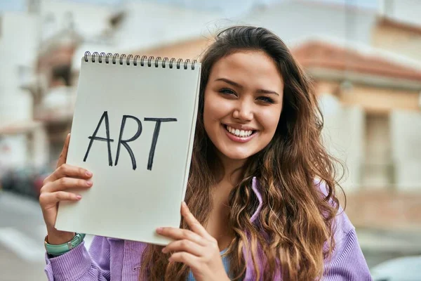 Joven Estudiante Arte Hispana Sonriendo Feliz Sosteniendo Cuaderno Ciudad —  Fotos de Stock