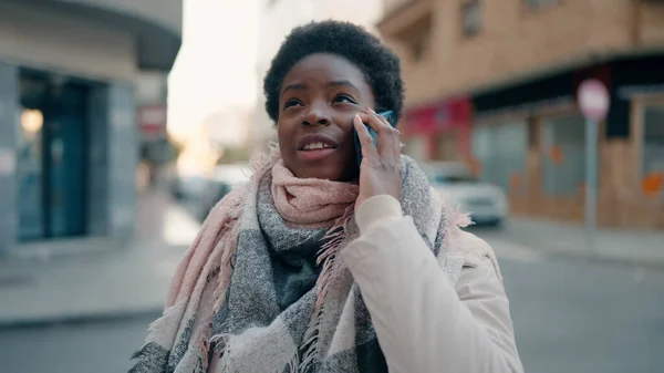 若いアフリカ系アメリカ人の女性が路上でスマートフォンで自信を持って話しています — ストック写真