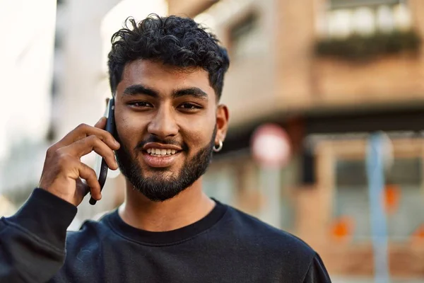 Young arab man smiling confident talking on the smartphone at street