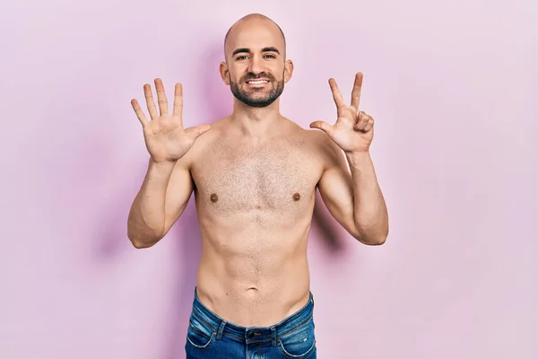 Młody Łysy Mężczyzna Stoi Bez Koszulki Pokazując Wskazując Palcem Numer — Zdjęcie stockowe