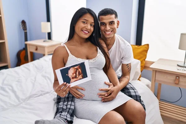 Young Latin Couple Expecting Baby Hugging Each Other Holding Ecography — Foto de Stock