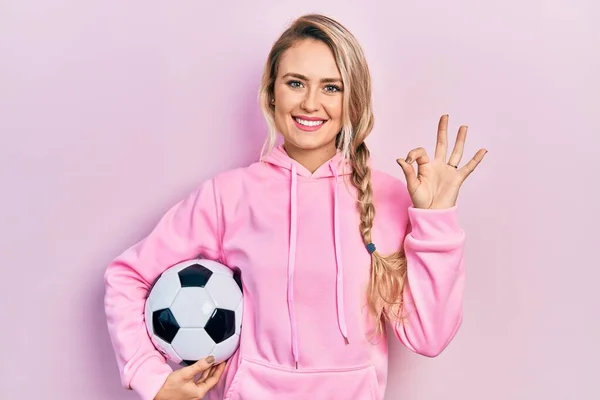 Linda Jovem Loira Segurando Bola Futebol Fazendo Sinal Com Dedos — Fotografia de Stock