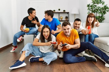 Evde oyun oynarken gülümseyen bir grup genç arkadaş..