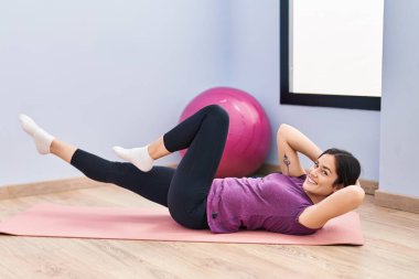 Spor merkezinde kendine güveni tam bir egzersiz yapan genç bir kadın.