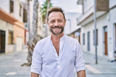 Yüzünde mutlu ve havalı bir gülümseme olan orta yaşlı bir adam. şanslı kişi. 