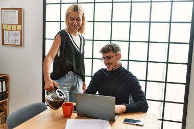 Ofiste çalışırken ve kahve içerken gülümseyen iki iş adamı..