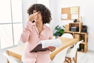 İş yerinde iş kıyafeti giyen genç bir ortadoğulu kadın pis ve iğrenç bir koku alıyor. Nefesini burnunda tutuyor. Kötü kokuyor. 