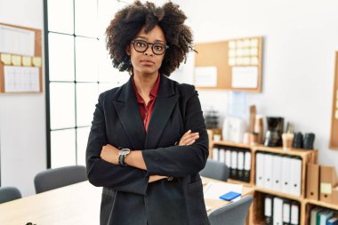 Young african american woman standing with arms crossed gesture at office