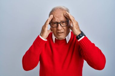 Senior man with grey hair standing over isolated background with hand on head, headache because stress. suffering migraine. 