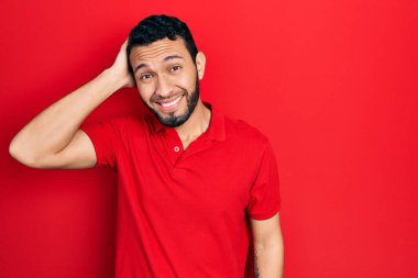 Sıradan kırmızı tişört giyen İspanyol sakallı adam soru sorup kafasını karıştırıyor. Şüpheyle kararsız, kafa kafaya düşünerek. Düşünceli kavram. 