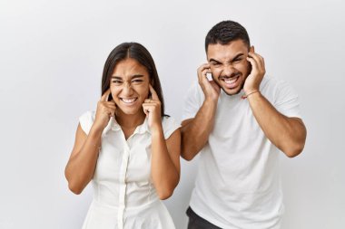 Soyutlanmış arka planda birbirine aşık genç bir çift yüksek sesli müzik gürültüsü için parmaklarıyla kulaklarını kapatıyor. sağır kavramı. 