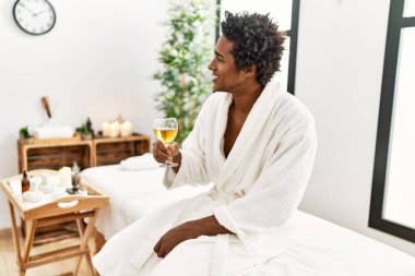 Genç Afro-Amerikalı adam masaj yaptırıyor. Güzellik merkezinde Tayland malı çantalar kullanıyor.