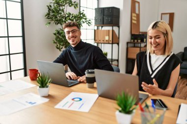 Ofiste video görüşmesi yapan iki iş adamı gülümsüyor..